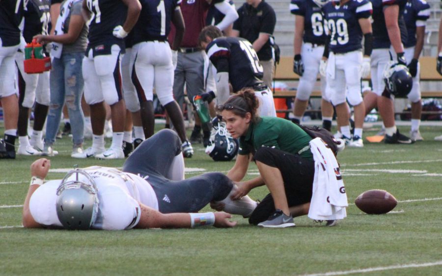 Athletic+trainer+Rebecca+Townsend+helps+an+injured+player+on+the+field+during+the+Southwest+vs.+Southeast+game.