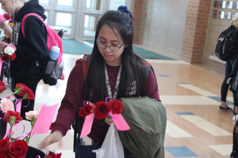 Senior Kim Cao picks up her flower order. Students can place orders for flowers until Wednesday the 13th from tables set up in the commons.