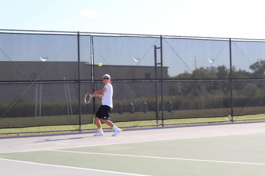 Logan Finley plays a singles match against a player from Southeast.