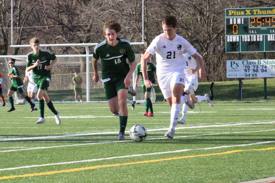 Tanner Novosad dribbling the ball past a Lincoln Pius X player.