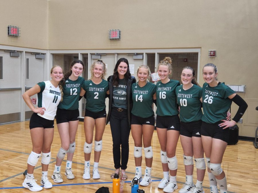 The JV volleyball team and coach Hannah Sexton pose for a picture. After the picture was taken the coach and the team shared a moment of celebration together. 