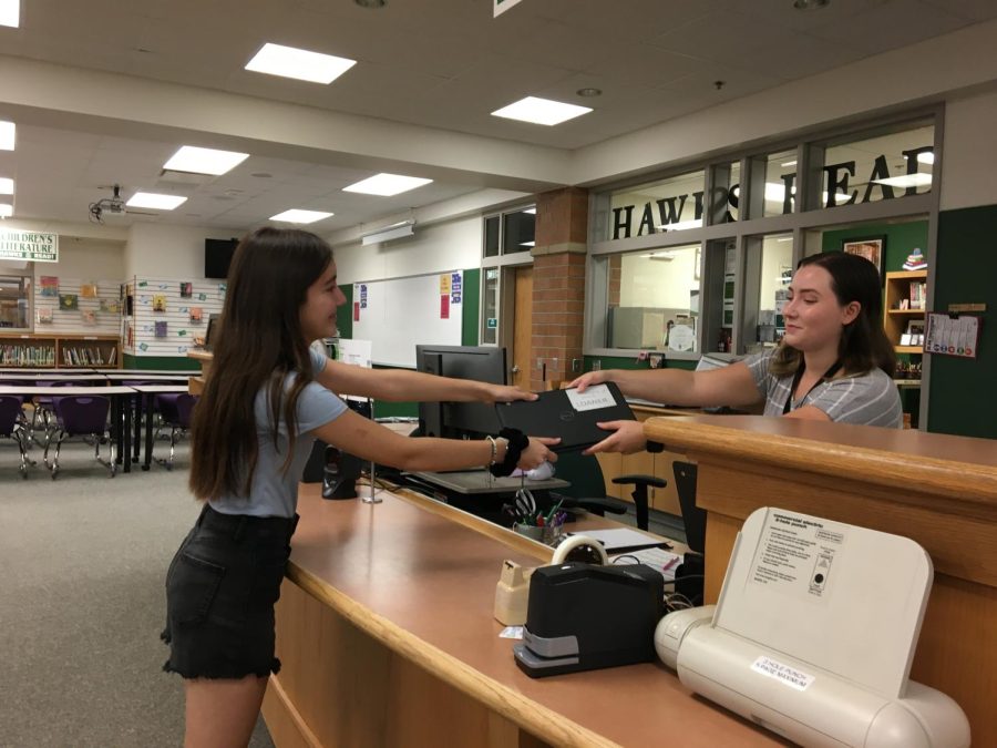 Senior Emely Chairez picks up a student loaner Chromebook from the Media Center. 
Students only receive a Chromebook if theirs is broken. 