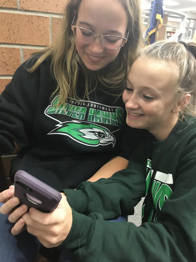 Senior Rachel Hemen helps Freshman Clara Bradbury with her Albegra problem on her phone.