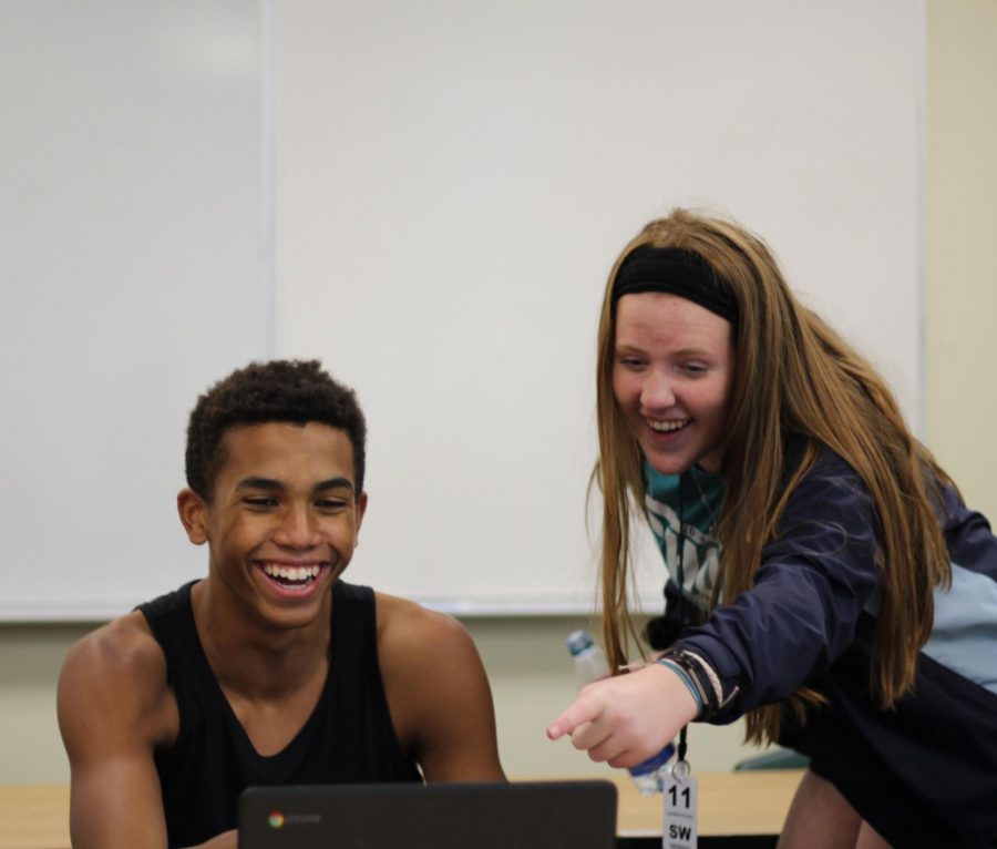 Freshman Jamison Focht and SHOS leader Junior Lauren Peters laugh at something on a chromebook