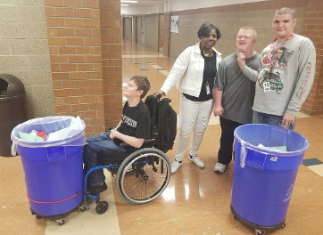 Sophomore Kaden Cook, para Frankie Williams, sophomore Jeff Evans 
 and senior Will Parish travel around the school,  taking out the recycling.