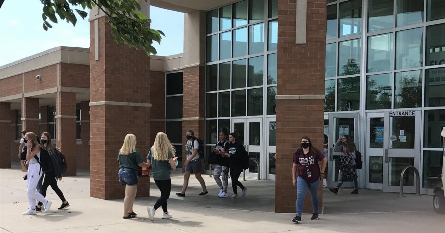 Students walk in and out of Lincoln Southwest High School. Students are required by LPS to wear face coverings in the building.