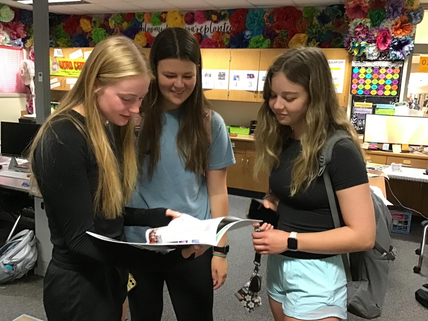 Students look at their yearbook. Those still wishing to collect their yearbooks can do so in Mrs. Brandi Benson’s room, C110. 