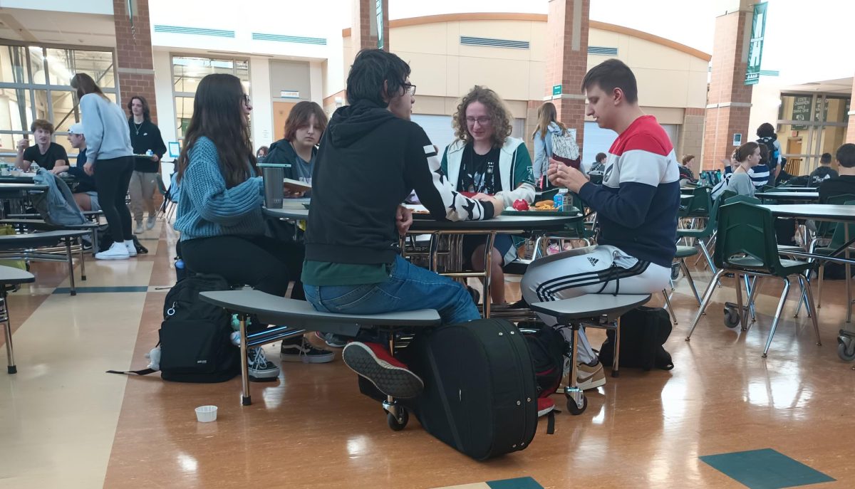 Students eat lunch at one of the new tables in the cafeteria. The 19 new tables were placed there on Wednesday, Oct. 18 for the start of term two.