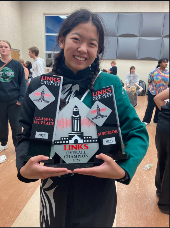 Drum+major+senior+Mimi+Hoffman+poses+with+the+varsity+marching+bands+newest+trophies.+Southwest+took+home+three+awards+on+Saturday%2C+Oct.+7+from+their+contest+at+Lincoln+High+School.