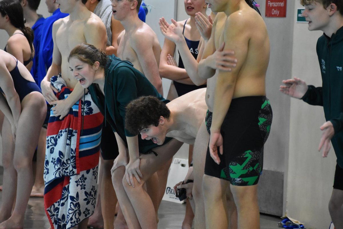 The swim team cheers on their teammates during the home meet on Thursday, Nov. 30. The Lincoln Southwest swim and dive team has many traditions such as singing the cheer, “ooh kah lay lah,” before every meet.