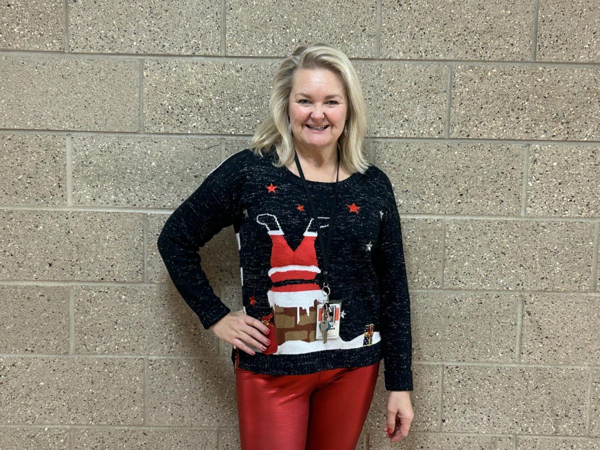 Media Center Secretary Michelle Winklepleck poses in her festive sweater for the first day of Winter Week. There are themed dress up days for the entire week of Dec. 4 - Dec. 8. 