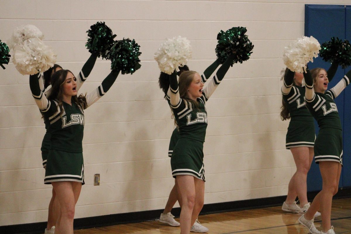 Cheerleaders rallies up the audience at basketball games. Cheerleader tryouts will be Friday, March 29.