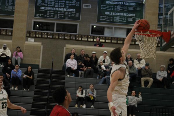 Junior Braden Frager dunking the basketball with one hand against Omaha South. The Hawks will face Millard South for Districts on Saturday, Feb. 24, at LSW at 3:00 p.m.