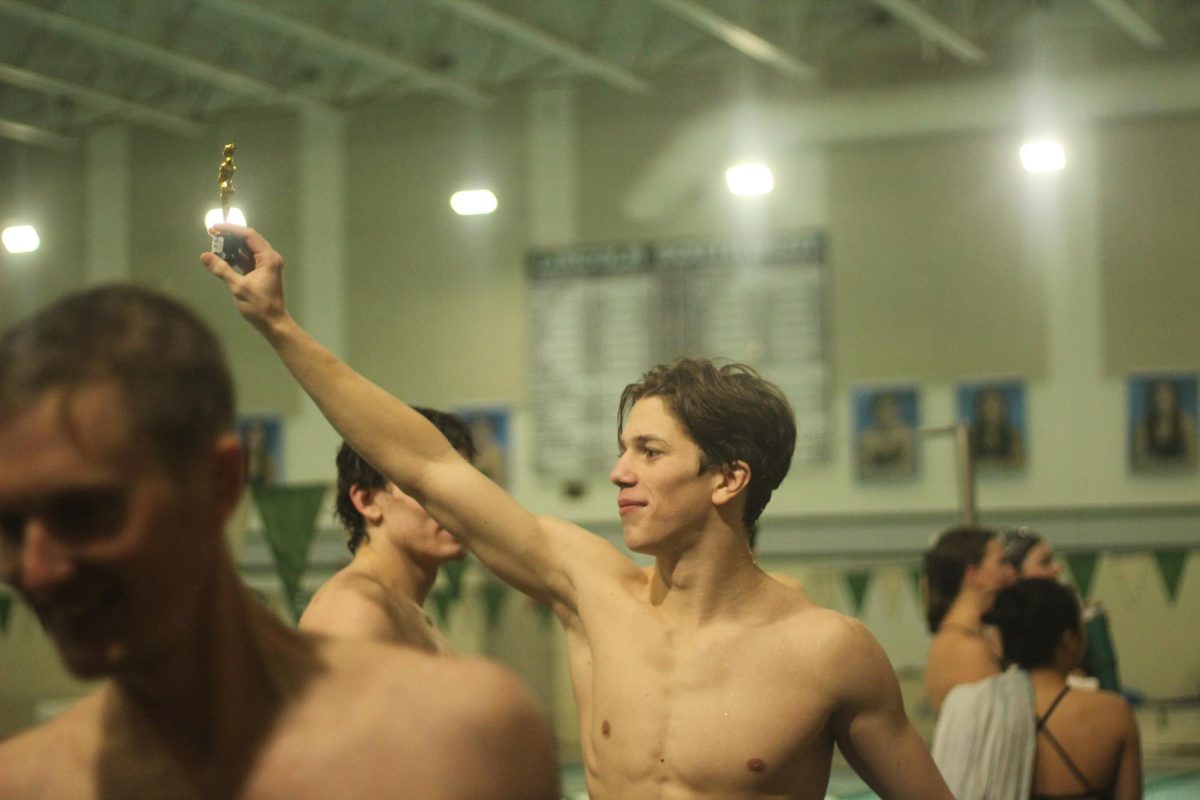 Senior Aidin Kolb holds a trophy after team wins against Norfolk. This was the last home meet of the season. 