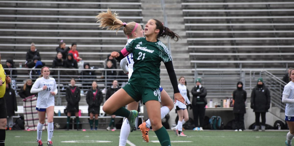 Senior Charley Kort jumping for the soccer ball. The Hawks won against Marian 1-1 in double overtime on Saturday, March 23, at Seacrest Field. 