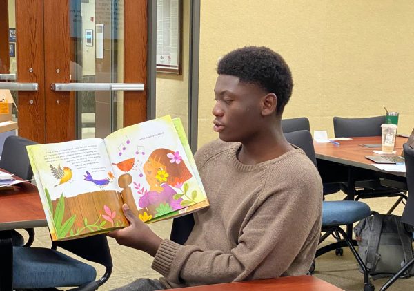 Senior Jeremiah Theork practices reading to prepare for his lesson with elementary students. The Equity Cadre has hosted multiple readings with elementary students since 2021.