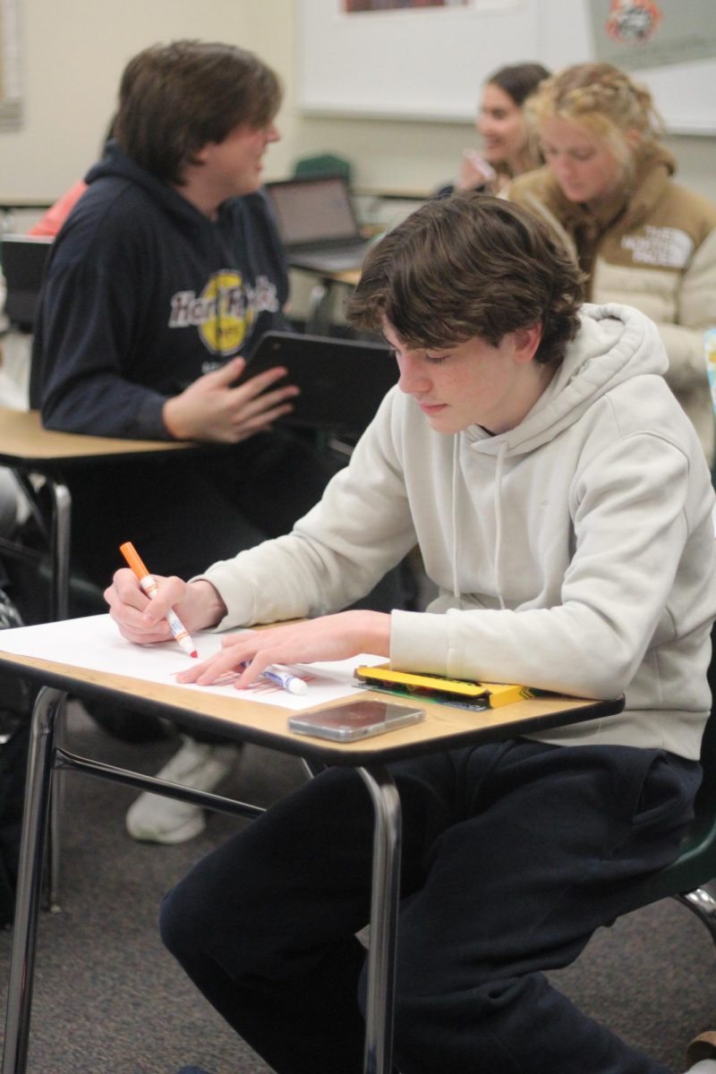 Alumni Jack McCormick decorates a poster during a TIE Club meeting. TIE Club makes posters for inclusivity week every year. 